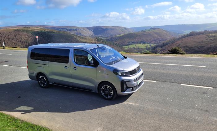 An electric vehicle on a road overlooking mountains